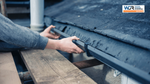 roofer inspecting shingle debris on gutter